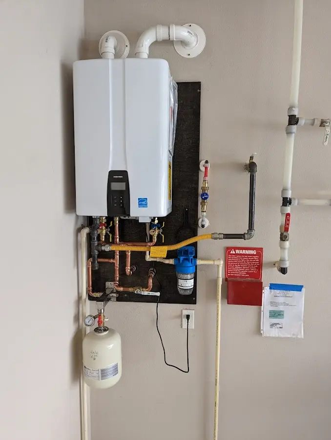 Professional plumber installing copper piping in a McDonald home